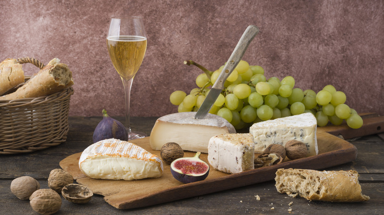 various cheeses, bread and grapes with a glass of prosecco