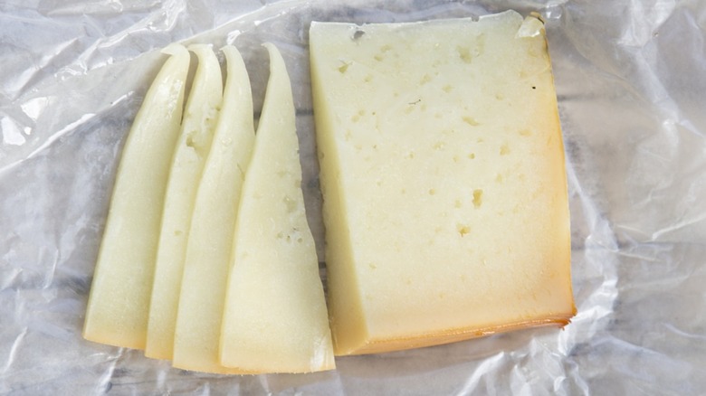 Overview of Idiazábal cheese sliced on a sheet of wax paper