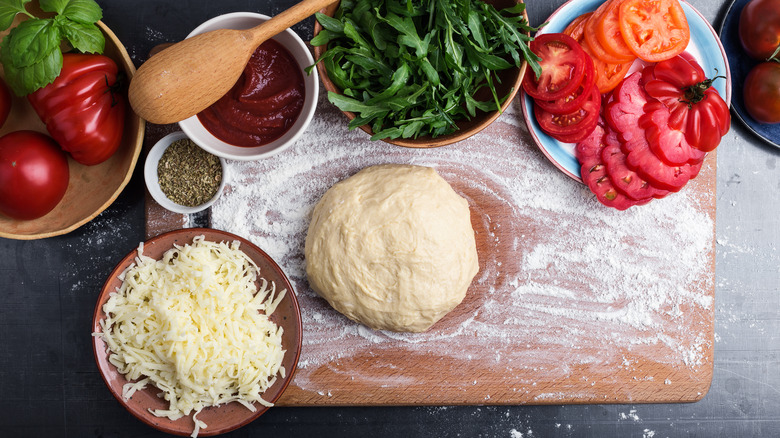 pizza dough surrounded by veggies