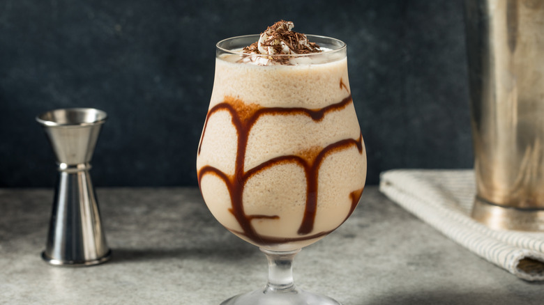 A chocolate mudslide in a glass with ribbons of chocolate drizzling inside the glass