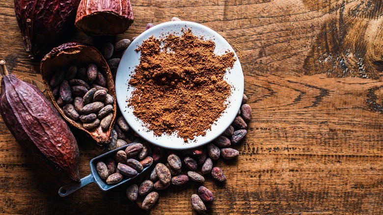 A plate of natural cocoa powder surrounded by cacao beans