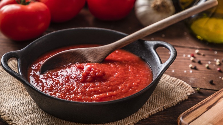 pomodoro sauce in a cast iron pan with a wooden spoon