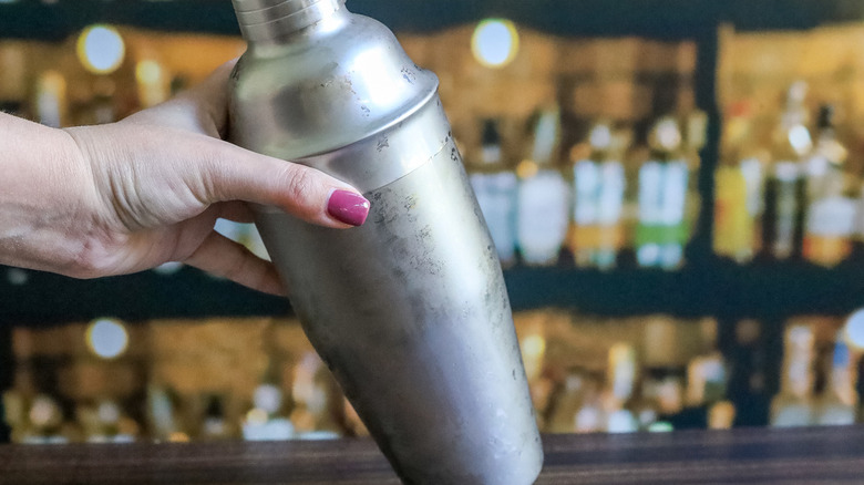 hand holding metal cocktail shaker