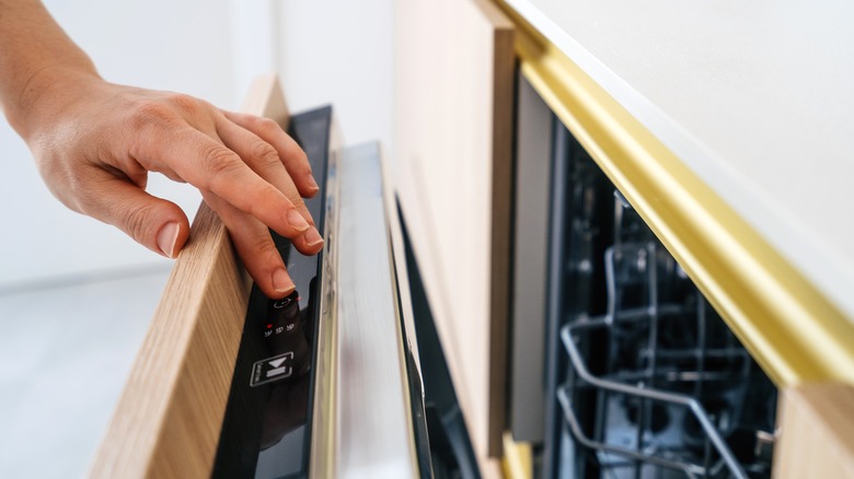 Hand turning on dishwasher