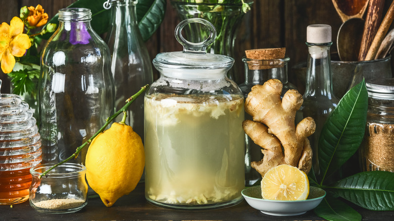 Jar of ginger beer with ginger, lemons, bottles