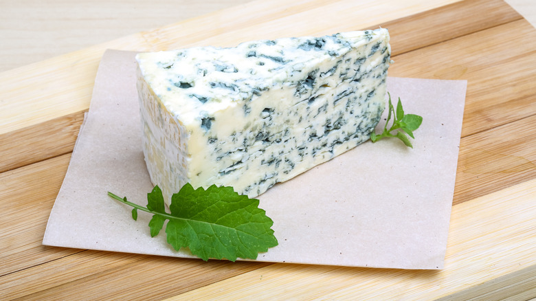 A wedge of blue cheese on a table