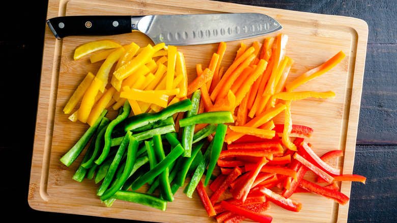 Bell pepper strips on a cutting board with knife