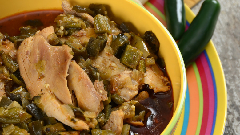 Chili verde with pork meat, served with tortillas and chilis on the side