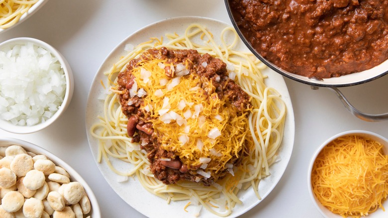 Cincinnati chili with bowls of chili, onions, cheese, and oyster crackers