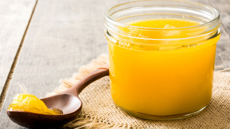 a jar of ghee with a wooden spoon