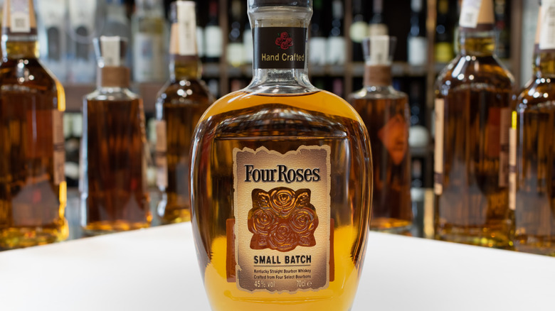 A bottle of Four Roses Small Batch Bourbon with faded bottles in the background