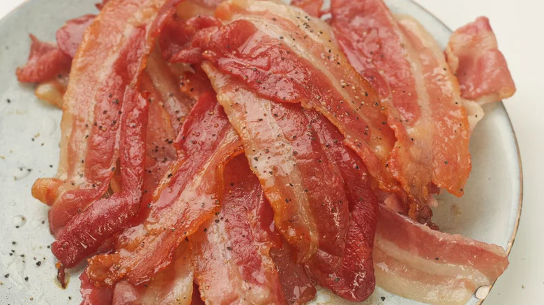 Stack of bacon on a plate with pepper