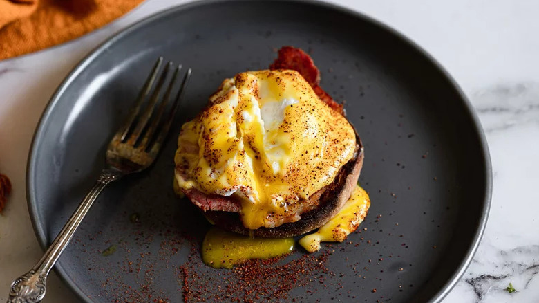 Plate of eggs Benedict wit fork