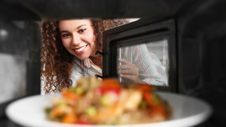 Person reheating food in microwave