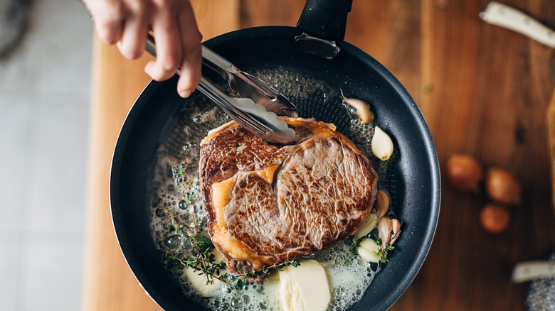 Ribeye steak with tongs