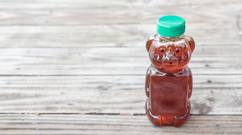 Honey in bear jar on table