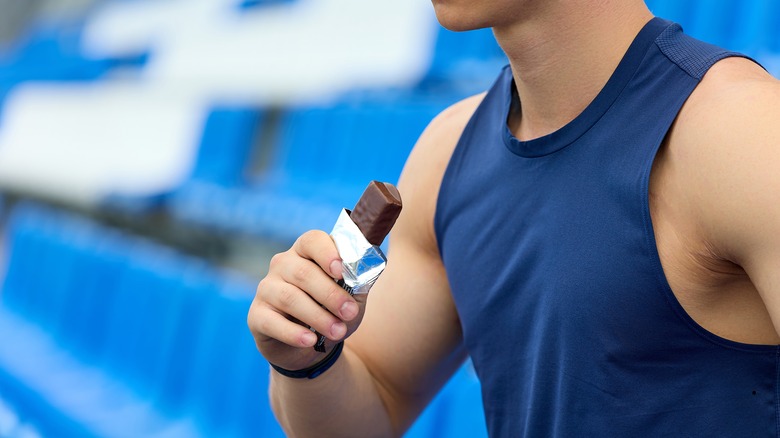 Person blue shirt protein bar