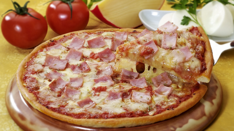 ham pizza with slice removed