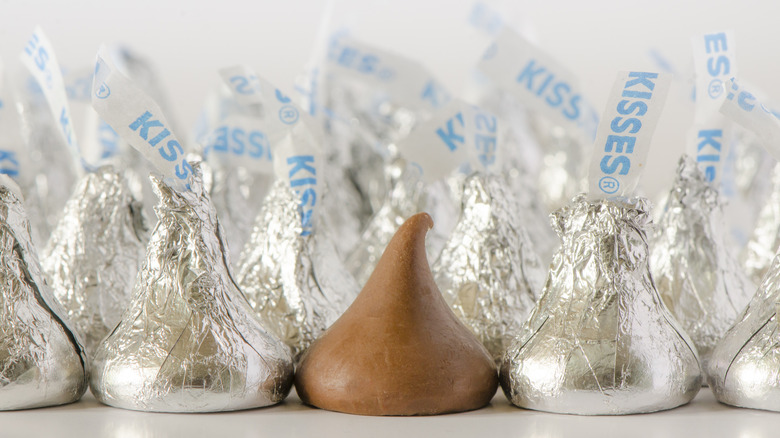 Closeup of Hershey's kisses, with a single unwrapped kiss