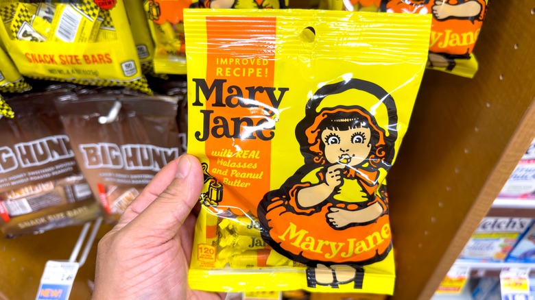 Hand holding bag of Mary Jane candy in a store