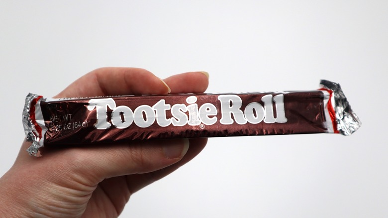 Hand holding a full-sized Tootsie Roll