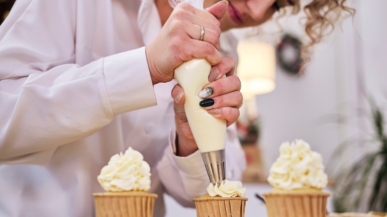 Pastry bag frosting cupcakes