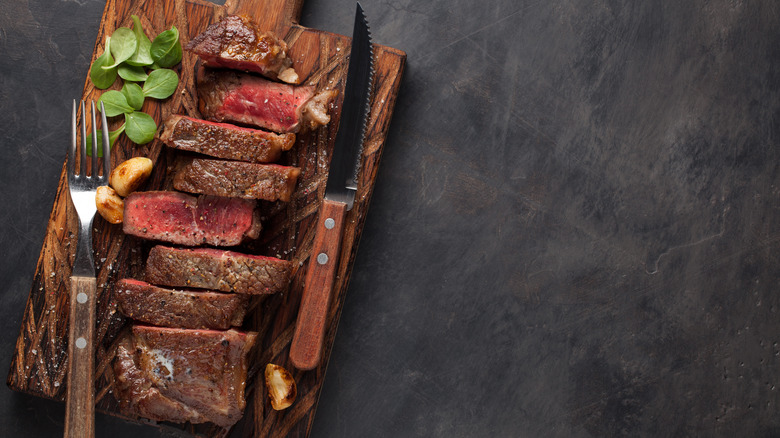 Steak knife on wooden board