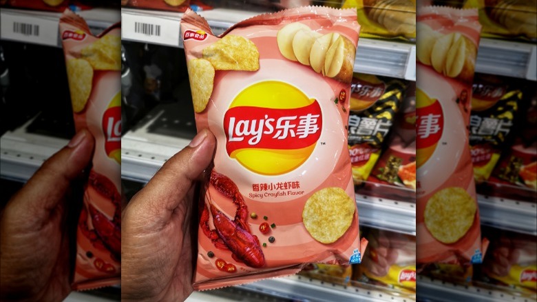 Person holding Spicy Crayfish chips bag