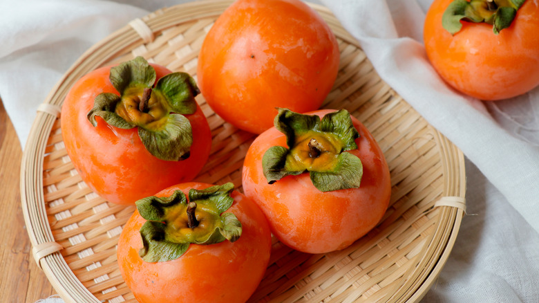 persimmons on a woven plate