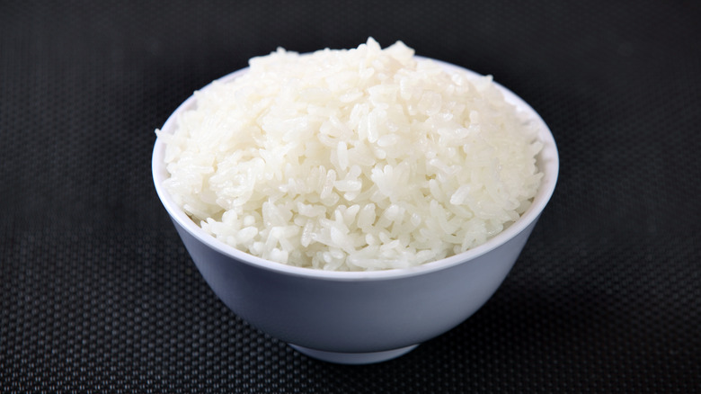 white rice in a white bowl with a black background