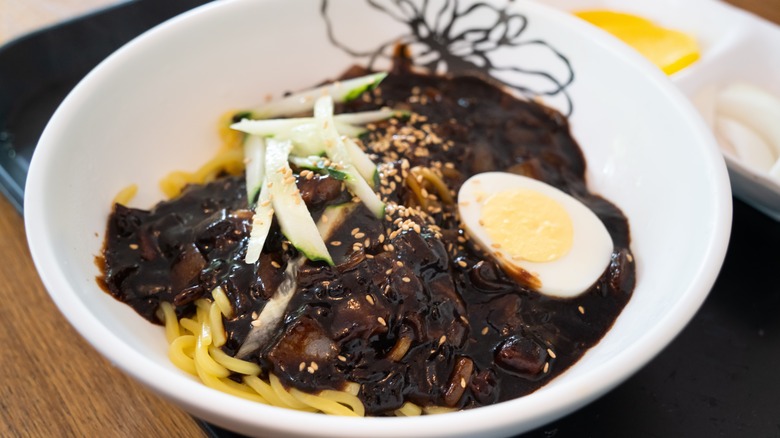 jjajangmyeon in white bowl with egg