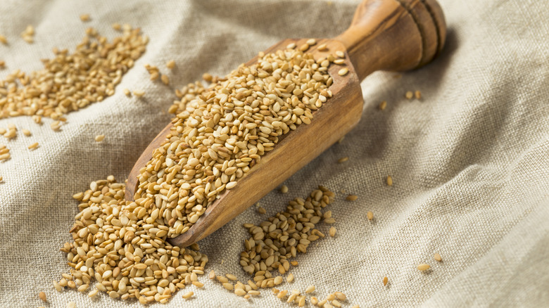 wooden scoop filled with toasted sesame seeds