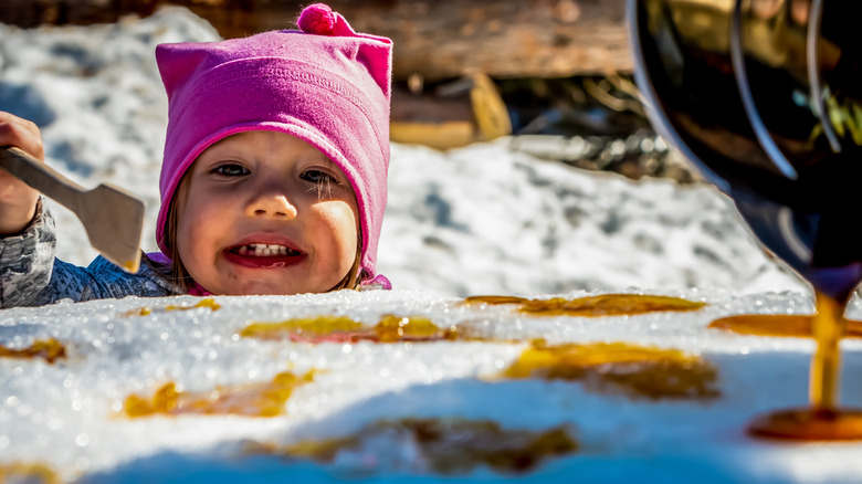 Child smiling with sugar-on-snow