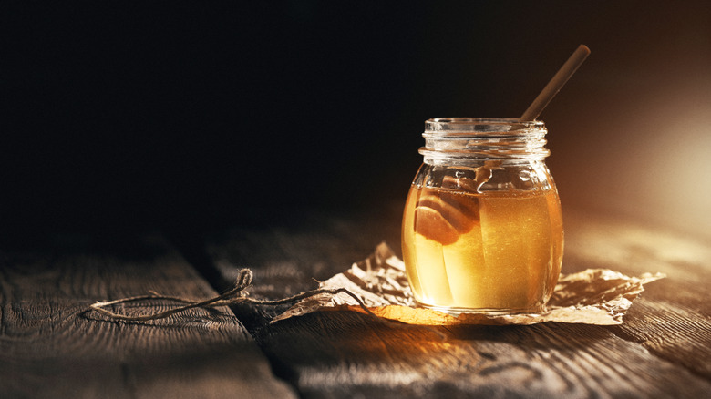 Honey jar on wooden table