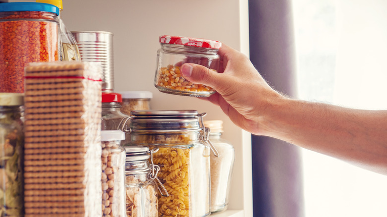 Person holding jar in pantry