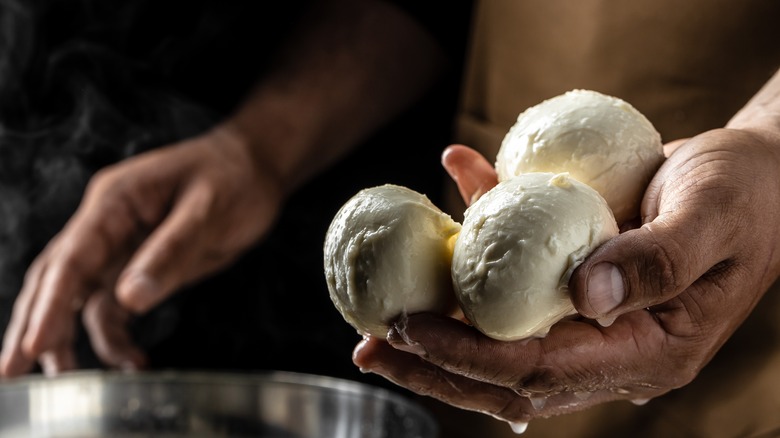 Fresh mozzarella balls in hand