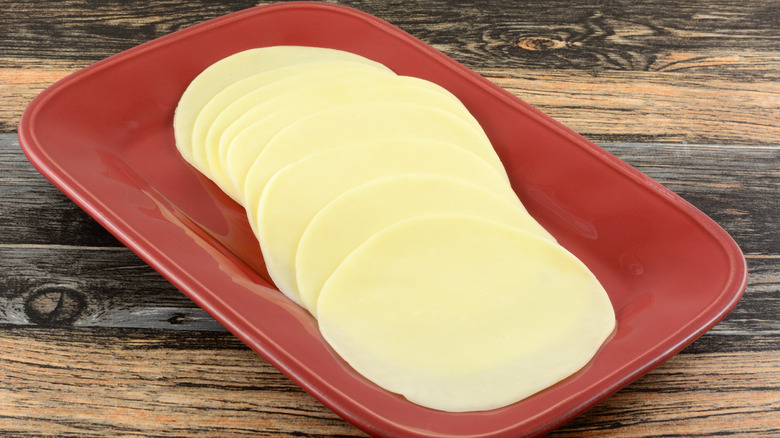 Sliced provolone on red plate