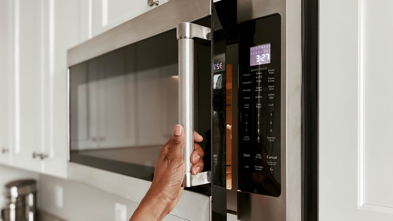 person opening microwave door