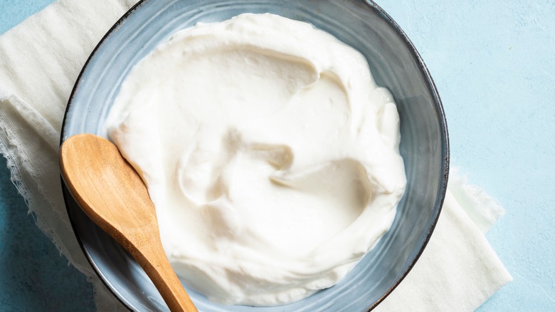 Bowl of sour cream with wooden spoon