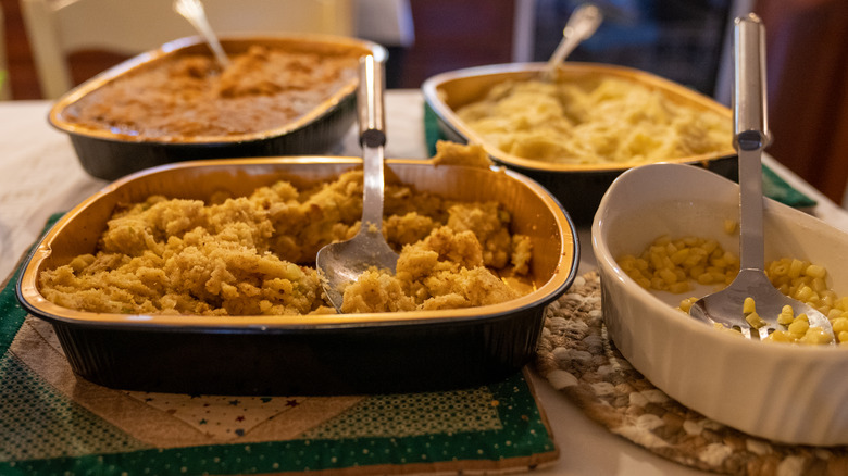 Thanksgiving serving dishes of stuffing, corn, and potatoes