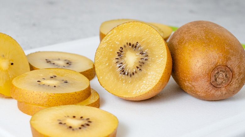 Close-up of whole and sliced gold kiwis