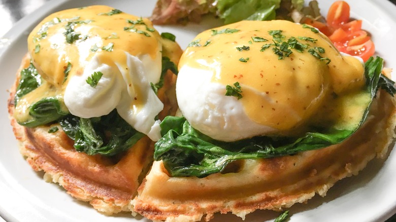 Eggs Benedict on waffles with fresh spinach