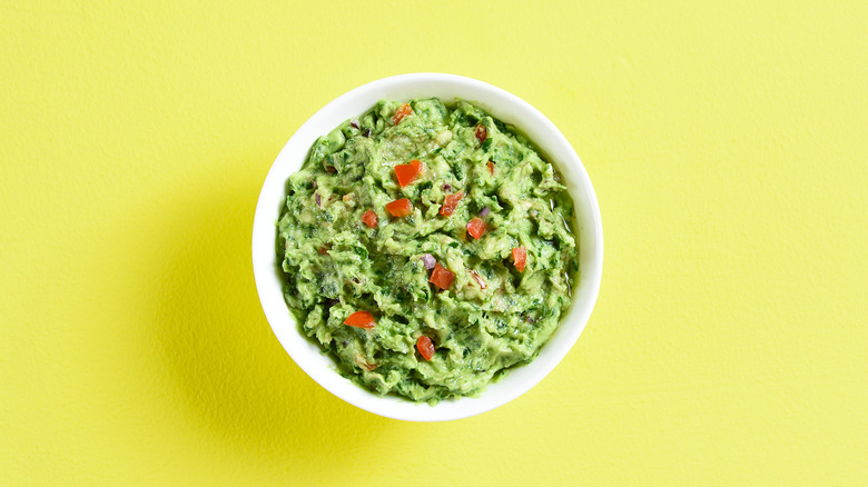 Guacamole in a bowl on a yellow background