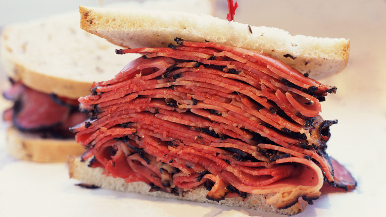 A sandwich stacked with slices of pastrami on a rye bread