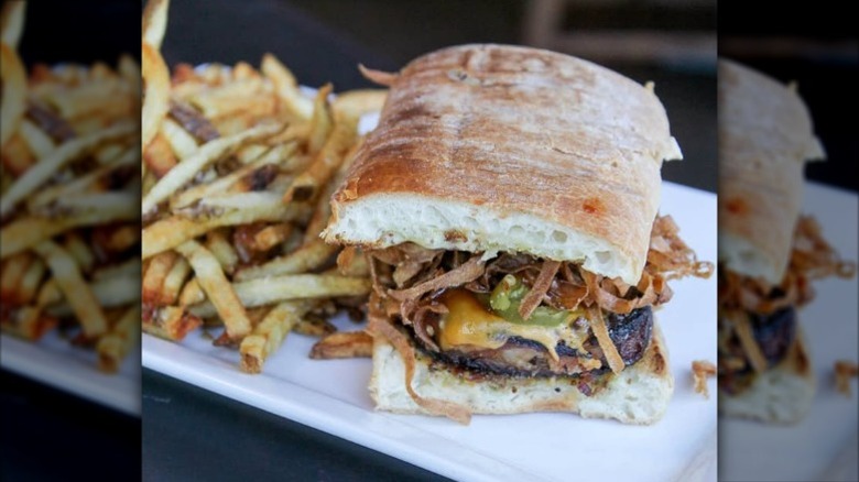 Meatloaf sandwich with cheese and frazzled onions on ciabatta with fries