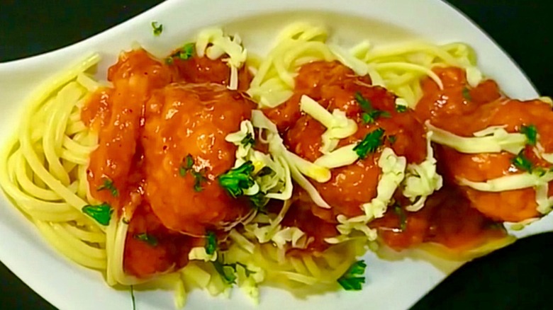 Spaghetti and meatballs plated with meatballs on top