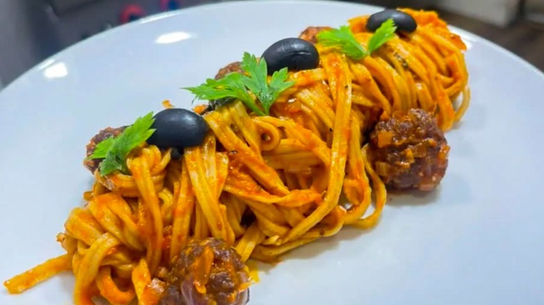 Spaghetti and meatballs arranged in a cylinder on a plate