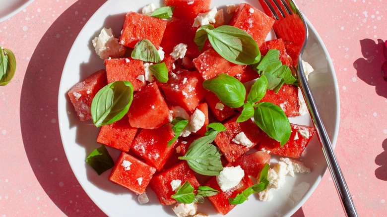 Top-down view of watermelon, feta, and basil salad on a plate