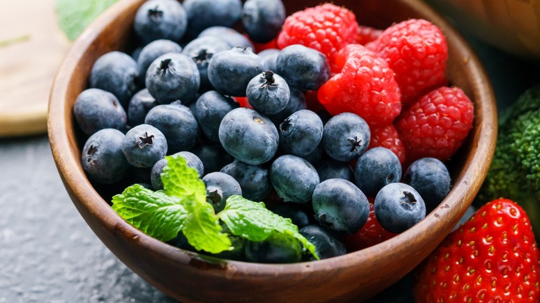 Close-up of blueberries, raspberries, and fresh mint in a bowl