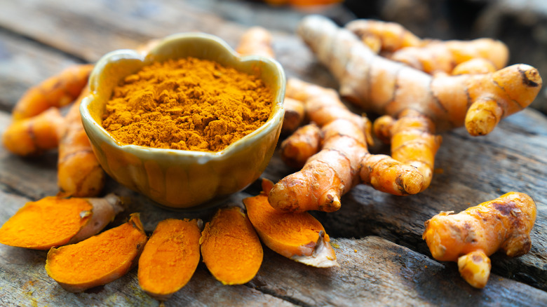 Fresh and dried turmeric on a wooden table